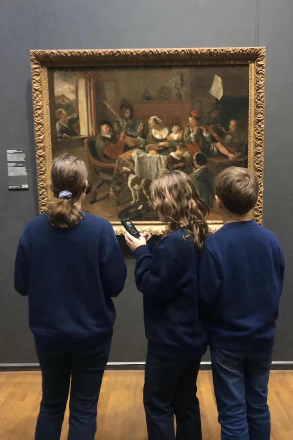 Kinderen bekijken een Gouden Eeuw-schilderij in een museum